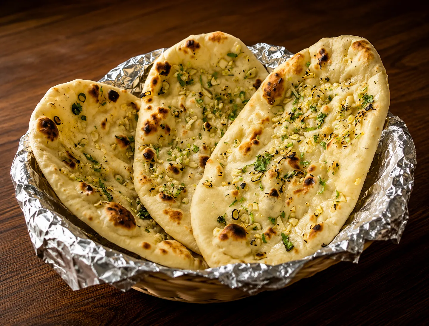 Fresh tandoor-baked naan breads brushed with butter at Tamarind East Indian Restaurant, Calgary